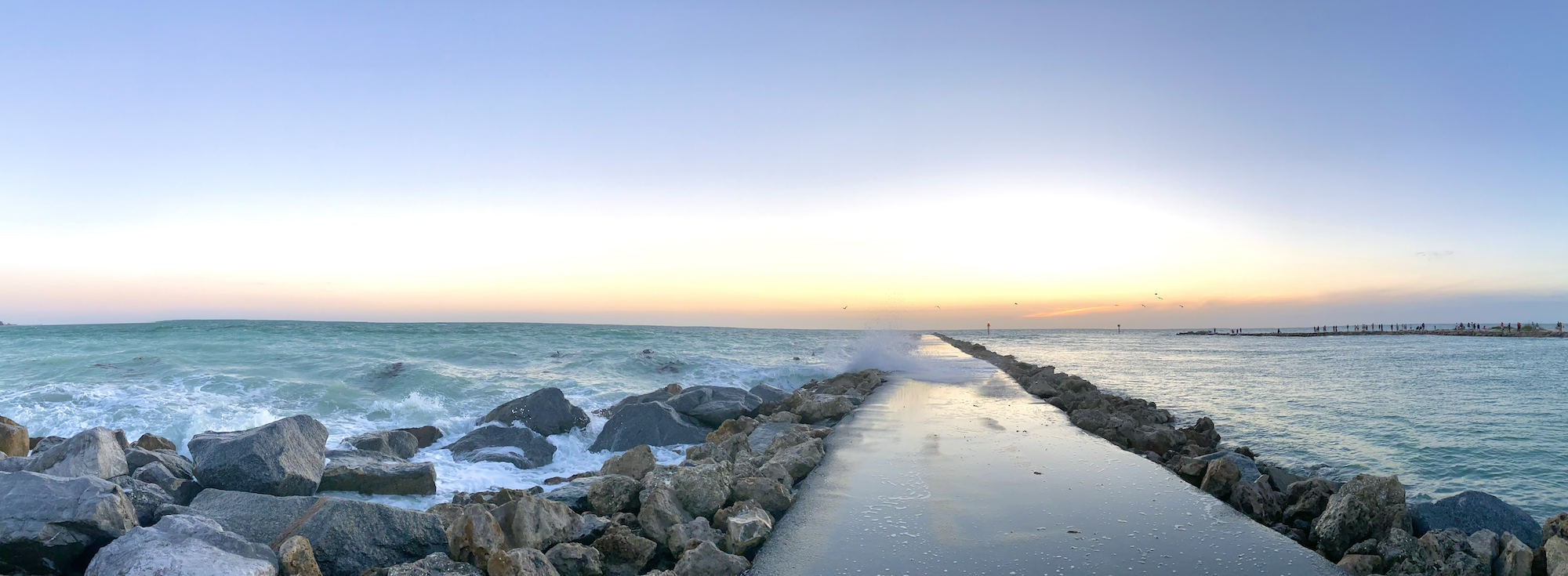Jetty stretching into the sea at sunset in color